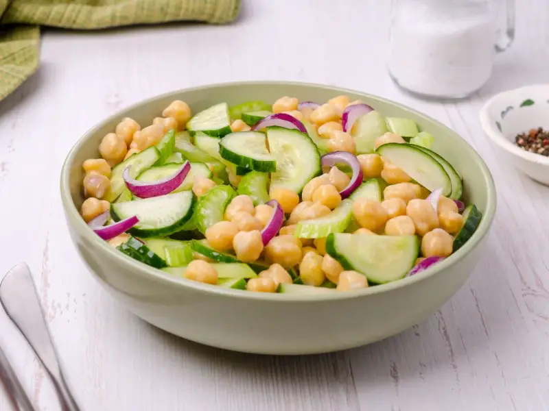 Insalata di ceci estiva con cetrioli freschi, cipolla rossa e sedano croccante, un piatto leggero e saporito.