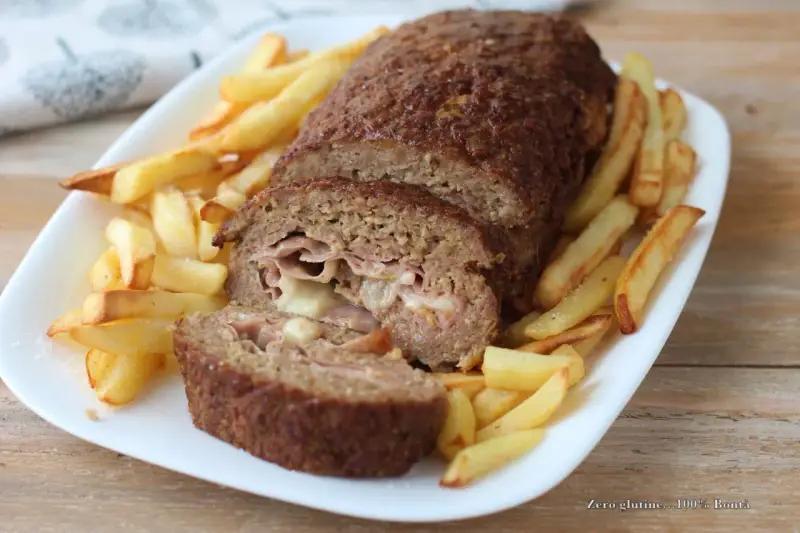 Polpettone ripieno di prosciutto e formaggio, cotto in friggitrice ad aria, servito con patatine fritte croccanti.